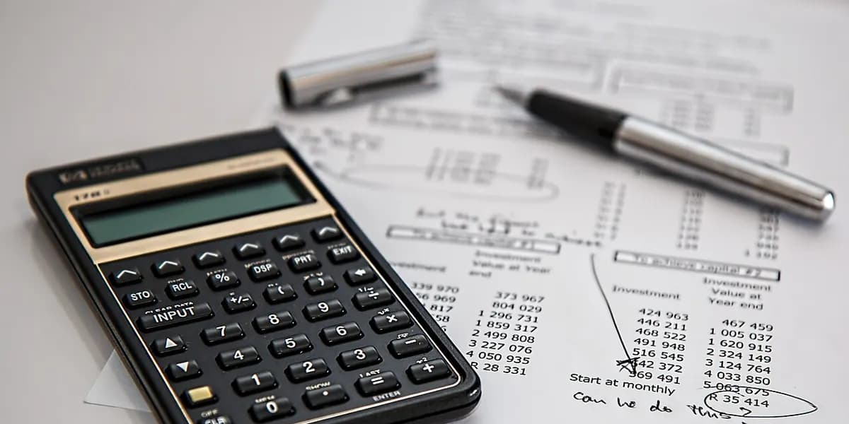 Calculator, pen and paperwork used to plan repayments